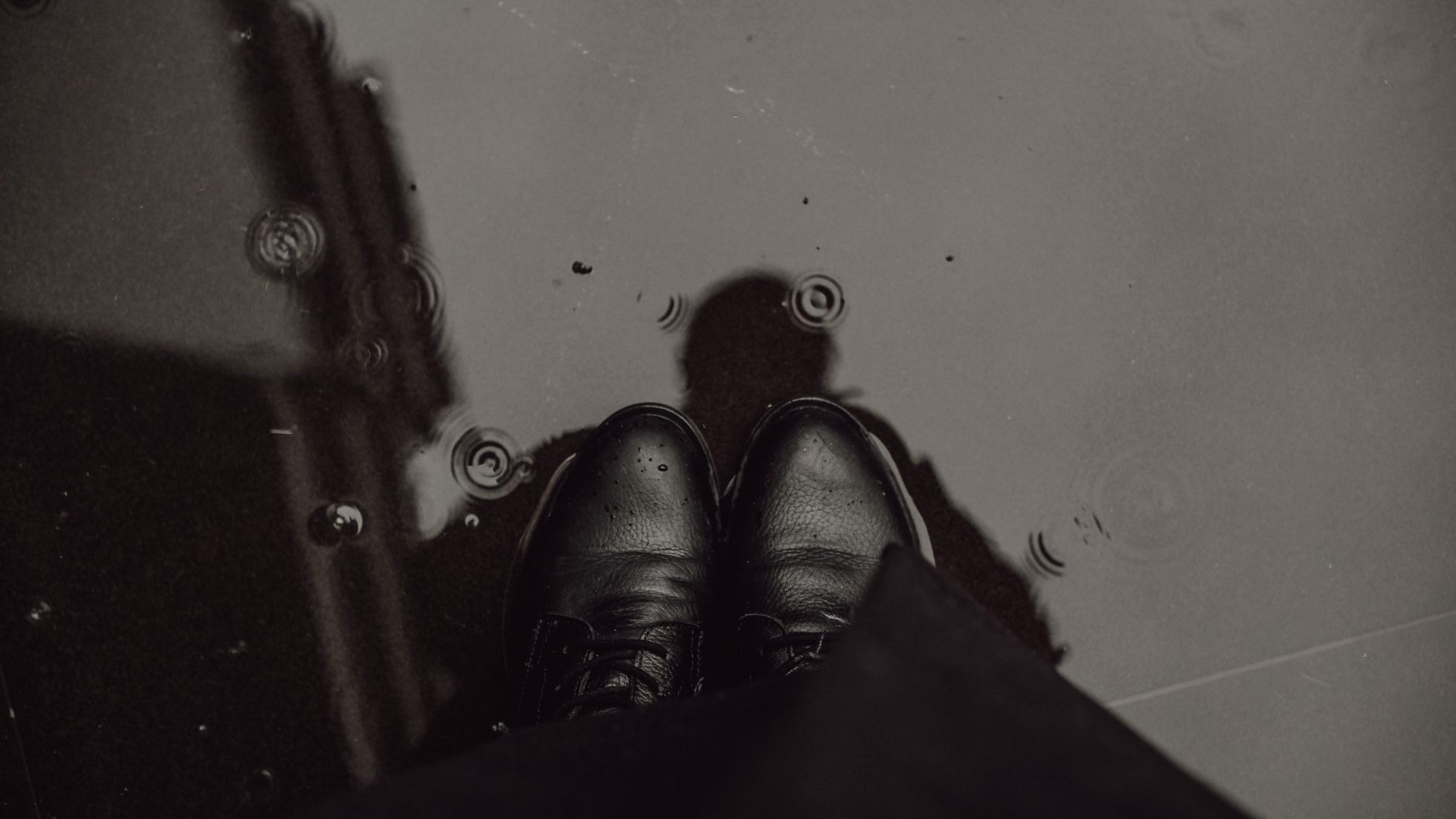 Chaussures en cuir noir dans une flaque d’eau un jour de pluie