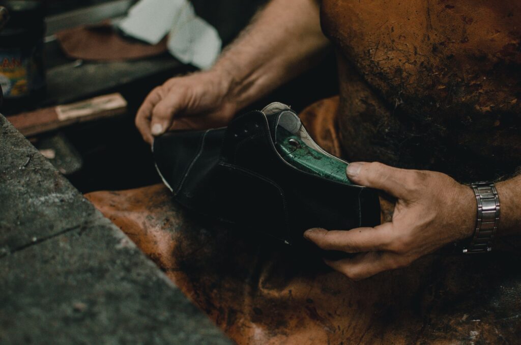Artisan cordonnier travaillant une chaussure à la main dans son atelier